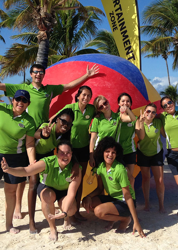 a group of staff membes on the beach smiling and having fun