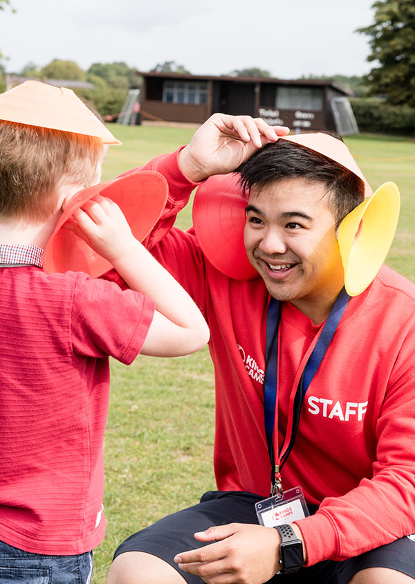 a red top and a child playing with sports cones