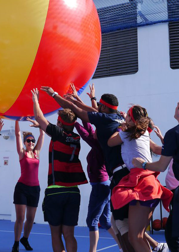 a group of people enjoying activities with a giant beach ball