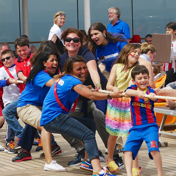 a group of adults and children playing tug of war