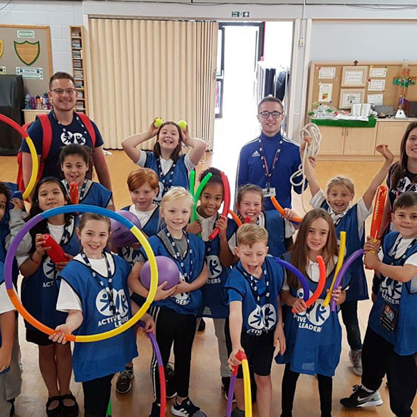 Active leaders children smiling holding sports equipment